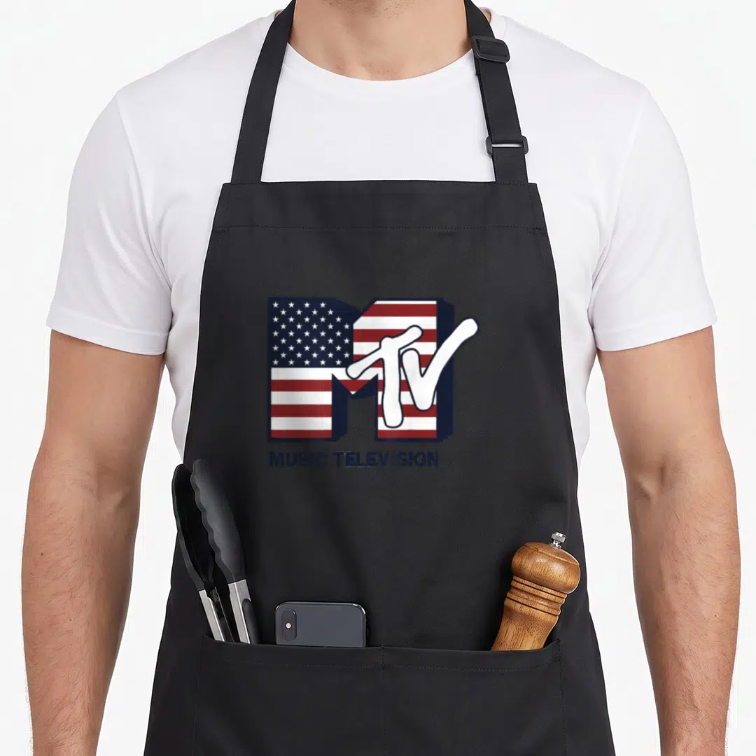 Mtv american flag apron - MTV logo with US flag pattern inside M and Music Television text below — shown on a black cotton canvas apron against a white background
