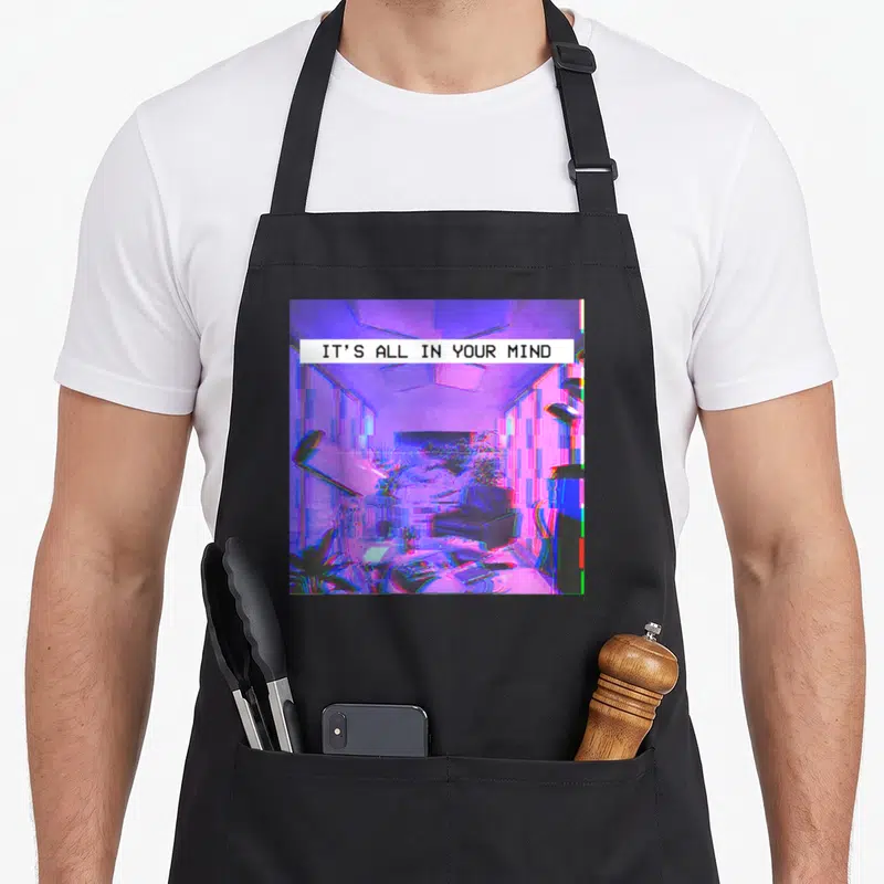 Emotional vaporwave apron - Pixelated purple room with glitch effects and white banner reading IT'S ALL IN YOUR MIND — shown on a black cotton canvas apron against a white background