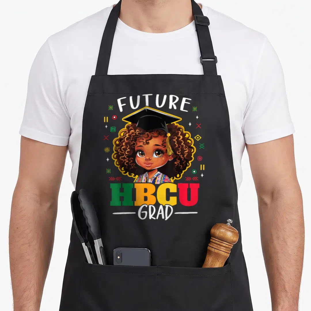 Grad future and apron - Cartoon girl with Afro and cap surrounded by FUTURE HBCU GRAD text and geometric shapes — shown on a black cotton canvas apron against a white background