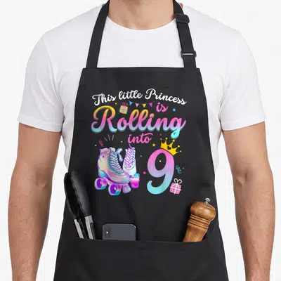 Roller skate birthday apron - This little Princess is Rolling into 9 with roller skates and crowned number 9 — shown on a black cotton canvas apron against a white background