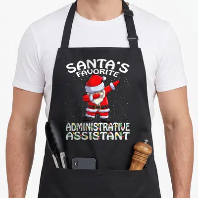 Administrative christmas apron - Dabbing Santa Claus with Santa's Favorite Administrative Assistant text and string — shown on a black cotton canvas apron against a white background