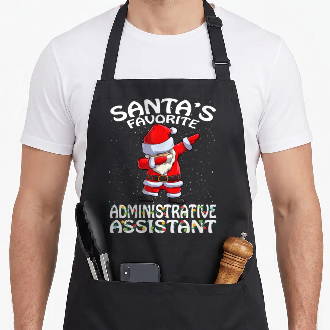 Administrative christmas apron - Dabbing Santa Claus with Santa's Favorite Administrative Assistant text and string — shown on a black cotton canvas apron against a white background