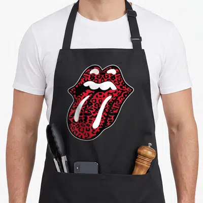 Tongue leopard apron - Red and black leopard print open mouth graphic outlined in white and black — shown on a black cotton canvas apron against a white background