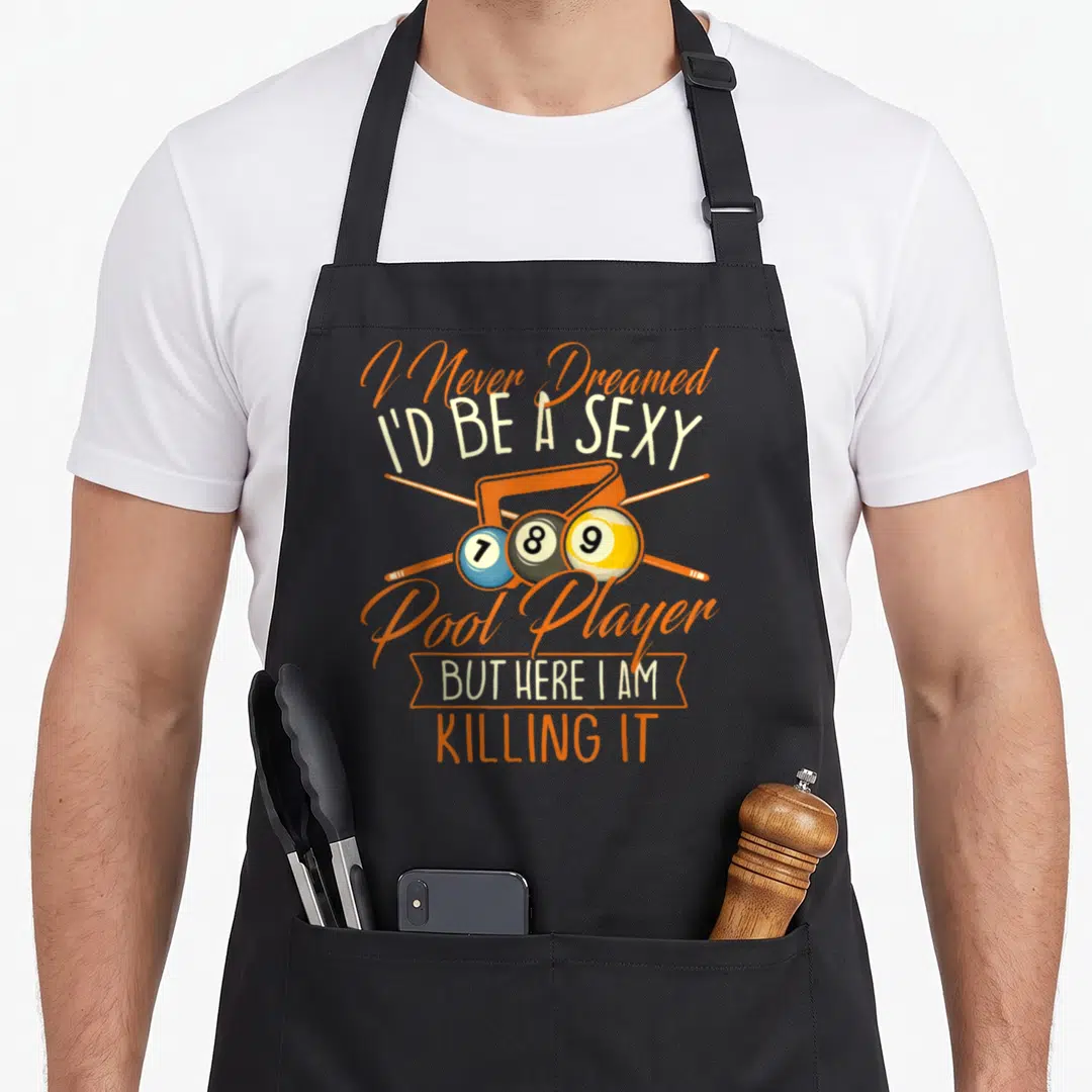 Dreamed snooker apron - Pool player pun text with three numbered balls and crossed cues in orange and blue — shown on a black cotton canvas apron against a white background
