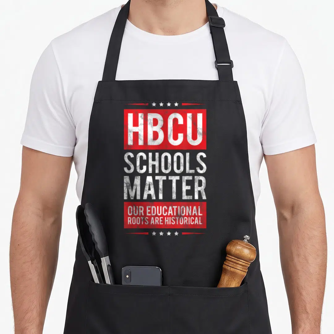 Distressed historical aprons - Red and white stacked text reading HBCU SCHOOLS MATRE with four stars above and below — shown on a black cotton canvas apron against a white background