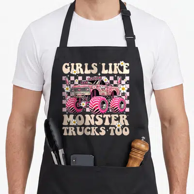 Monster truck aprons for dad - Pink cartoon monster truck with smiley flowers and checkered background — shown on a black cotton canvas apron against a white background
