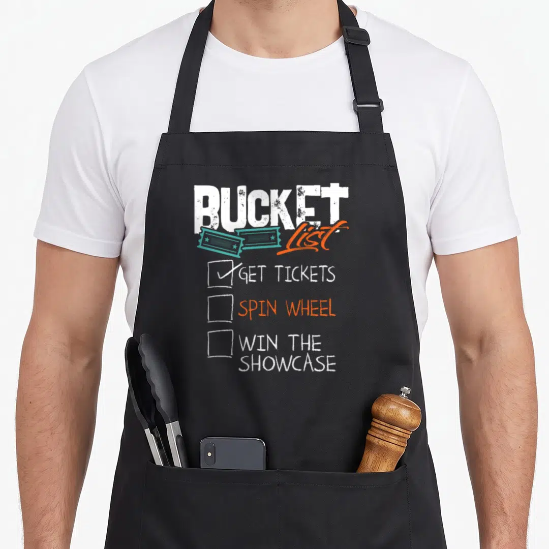 Wheel bucket apron - Distressed BUCKET List text with teal tickets and a three-item game show checklist — shown on a black cotton canvas apron against a white background