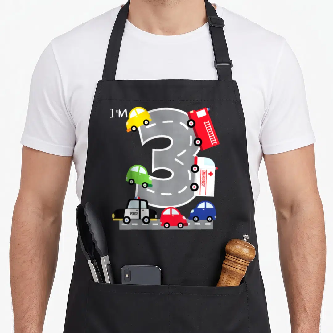 Transportation truck apron - Number 3 road design with toy police fire and emergency vehicles in cartoon style — shown on a black cotton canvas apron against a white background