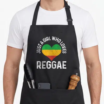Music reggae apron - Distressed heart in green yellow and red with white text just a girl who loves reggae — shown on a black cotton canvas apron against a white background