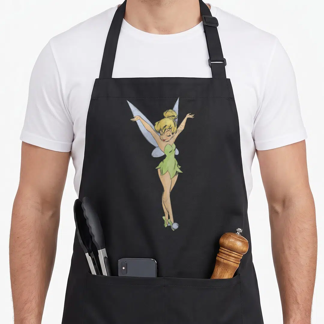 Arm bell apron - Cartoon Tinker Bell with blonde hair and green dress raising arms with white wings — shown on a black cotton canvas apron against a white background