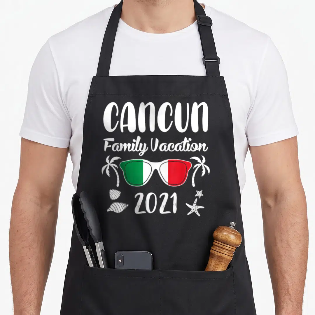 Family mexico apron - CANCUN Family Vacation 2021 sunglasses palm trees seashells starfish cartoon — shown on a black cotton canvas apron against a white background