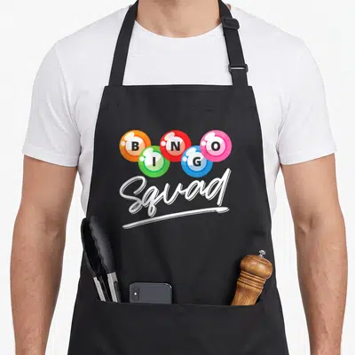 Squad bingo apron - Five colored bingo balls spelling BINGO above white Squad script — shown on a black cotton canvas apron against a white background