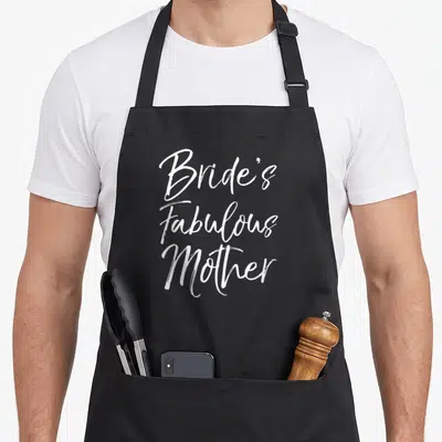Family bride bridal apron - White script text reading Bride's Fabulous Mother on black background — shown on a black cotton canvas apron against a white background
