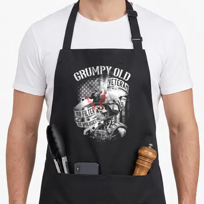 Grumpy veteran patriotic apron - Distressed skeleton soldier in helmet with GRUMPY OLD VETERAN text and red accents — shown on a black cotton canvas apron against a white background
