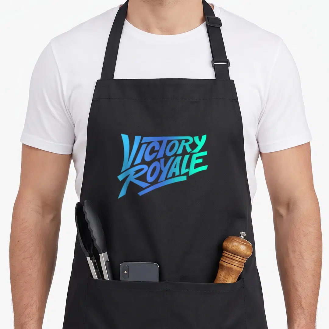 Royale trend apron - Stacked VICTORY ROYALE text in blue and teal gradient typography — shown on a black cotton canvas apron against a white background