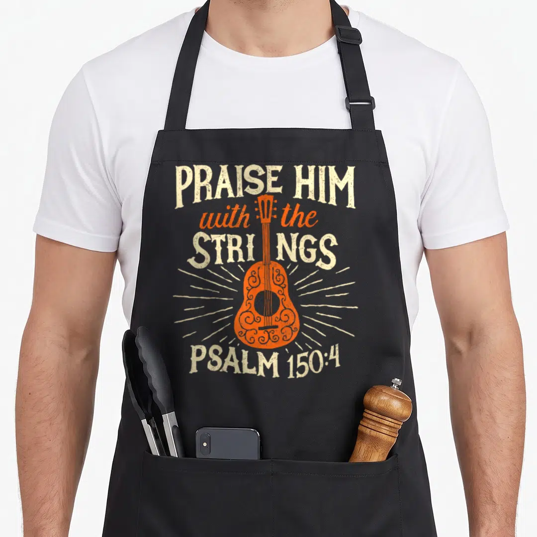 Praise christian music apron - Distressed orange guitar with Praise Him with the Strings Psalms 150:4 text — shown on a black cotton canvas apron against a white background