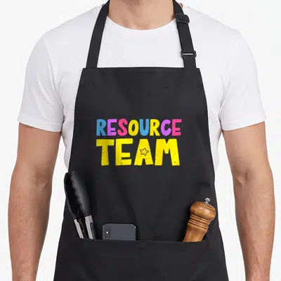 Resource special teacher apron - Stacked RESOURCE TEAM text in blue pink and yellow with star inside letter — shown on a black cotton canvas apron against a white background