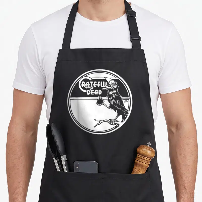 Wake black crow apron - GRATEFUL DEAD text and grey crow on branch inside white circular border — shown on a black cotton canvas apron against a white background