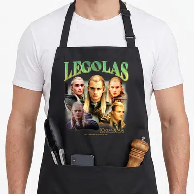 Elf ring apron - Five photo portraits of Legolas with green arched text and gold movie title logo — shown on a black cotton canvas apron against a white background