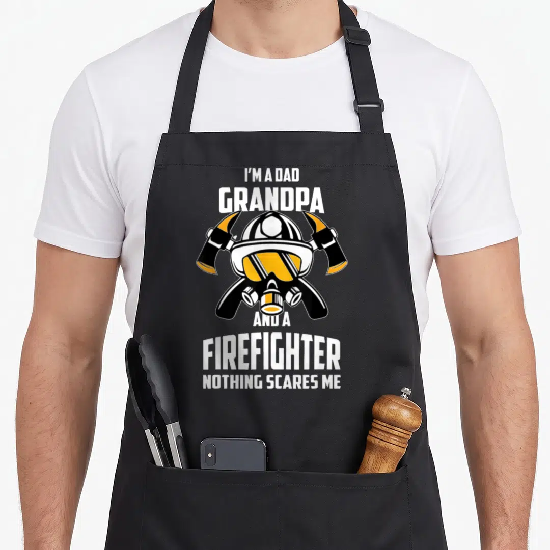 Grandpa fireman firefighter aprons - I'm a Dad Grandpa Firefighter Nothing Scares Me text with helmet and crossed axes — shown on a black cotton canvas apron against a white background
