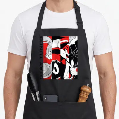 Stay jam apron - Four vertical cartoon character panels with vertical STAY TUNED text in black white and red — shown on a black cotton canvas apron against a white background