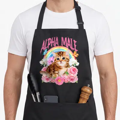 Kitten alpha apron - Pink ALPHA MALE text over rainbow, brown kitten, pink roses, blue butterfly — shown on a black cotton canvas apron against a white background