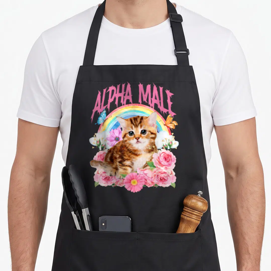 Kitten alpha apron - Pink ALPHA MALE text over rainbow, brown kitten, pink roses, blue butterfly — shown on a black cotton canvas apron against a white background