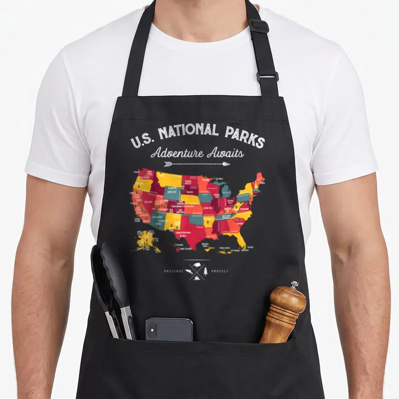 Map hiking camping apron - Colorful US map with U.S. National Parks text and preserve protect camping icons — shown on a black cotton canvas apron against a white background