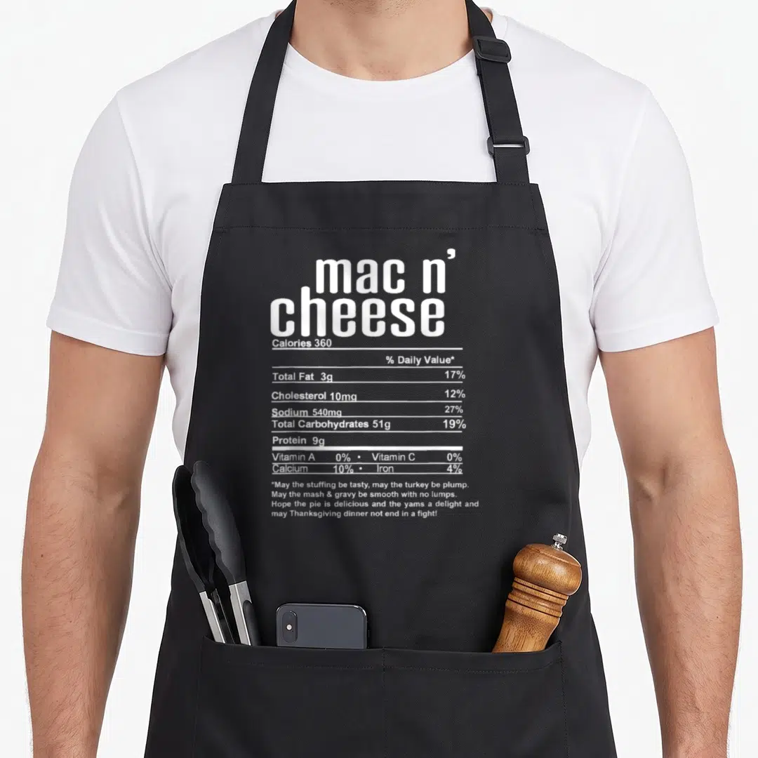 Thanksgiving mac apron - White nutrition label graphic for mac n cheese with a Thanksgiving blessing about a peaceful — shown on a black cotton canvas apron against a white background