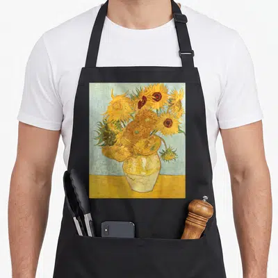 Vincent sunflower van gogh apron - Yellow sunflowers in a white vase marked Vincent on a blue background — shown on a black cotton canvas apron against a white background