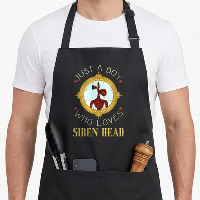Cryptid novelty apron - Siren Head figure in gold frame with text Just a Boy Who Loves Siren Head and four red hearts — shown on a black cotton canvas apron against a white background