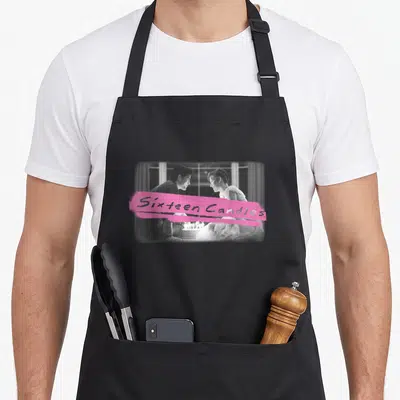 Cake birthday apron - Pink brushstroke reading Sixteen Candles over black and white couple photo — shown on a black cotton canvas apron against a white background