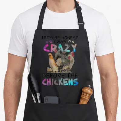 Honest before chicken apron - Chicken photo with LET'S BE HONEST text and pink blue gradient letters — shown on a black cotton canvas apron against a white background