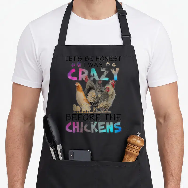 Honest before chicken apron - Chicken photo with LET'S BE HONEST text and pink blue gradient letters — shown on a black cotton canvas apron against a white background