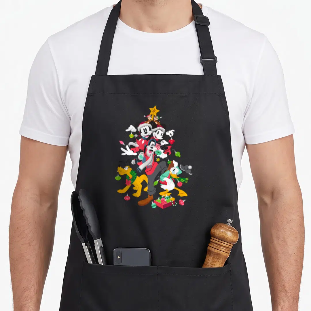 Pluto christmas tree apron - Disney characters arranged in a Christmas tree shape with a star and gift box — shown on a black cotton canvas apron against a white background
