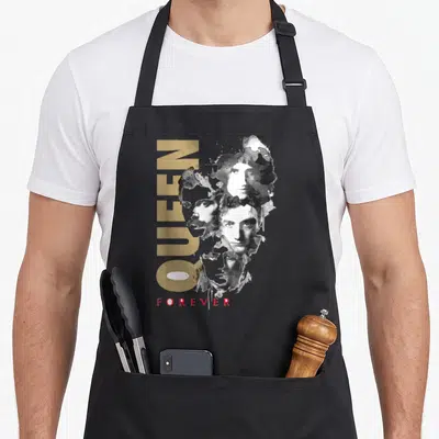 Forever queen apron - Gold QUEEN text, watercolor four faces, red FOREVER text on grey background — shown on a black cotton canvas apron against a white background