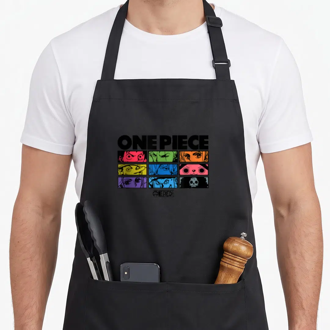 Eye anime character apron - ONE PIECE text above 3x3 grid of colorful character eyes and a skull logo — shown on a black cotton canvas apron against a white background