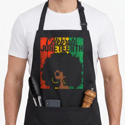 Celebrate african apron - Distressed Celebrate JUNETEENTH text over red yellow green stripes with afro woman silhouette — shown on a black cotton canvas apron against a white background