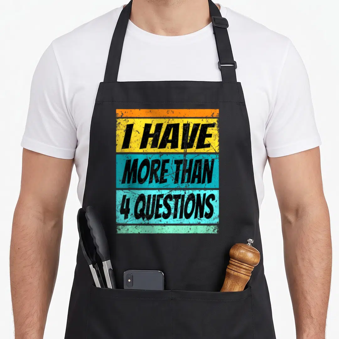 Four passover apron - I HAVE MORE THAN 4 QUESTIONS text on five colored horizontal stripes in retro style — shown on a black cotton canvas apron against a white background