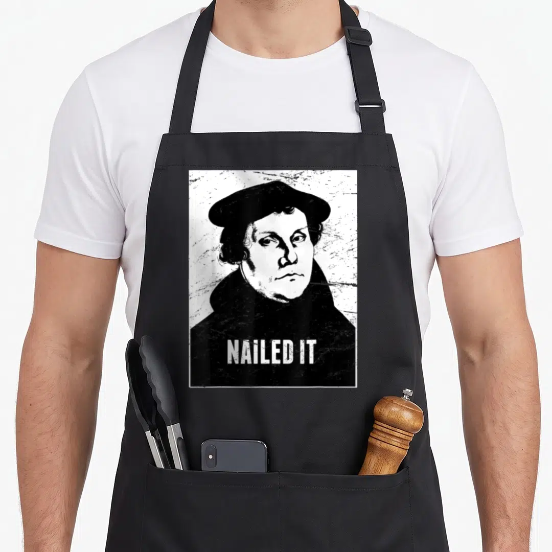 Lutheran nailed it aprons - Distressed black and white portrait of man in beret with NAILED IT text — shown on a black cotton canvas apron against a white background