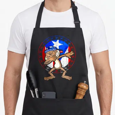 Puerto bandana apron - Cartoon monkey dabbing in front of Puerto Rico flag emblem with Taino symbols — shown on a black cotton canvas apron against a white background