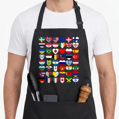 Flag country apron - 48 heart-shaped national flags in red blue yellow green white grid — shown on a black cotton canvas apron against a white background