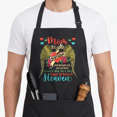 Memorial family aprons - Red heart with gold wings and birthday wish text for mom in heaven — shown on a black cotton canvas apron against a white background