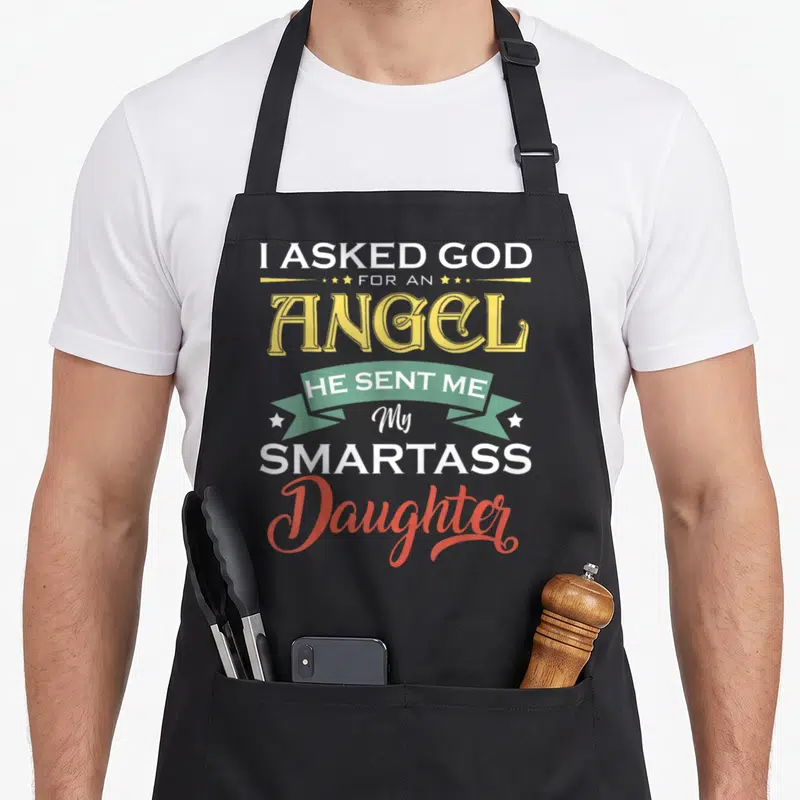 Asked angel mom daughter apron - Stacked text I Asked God For An Angel He Sent Me My Smartass Daughter with green — shown on a black cotton canvas apron against a white background