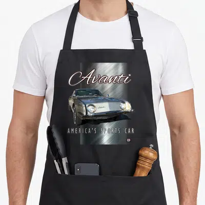Avanti car apron - Silver Studebaker Avanti photo on brushed metal background with text — shown on a black cotton canvas apron against a white background