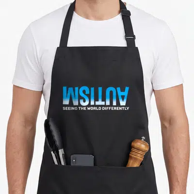 Differently autism apron - Mirrored blue autism text above white seeing the world differently typography — shown on a black cotton canvas apron against a white background