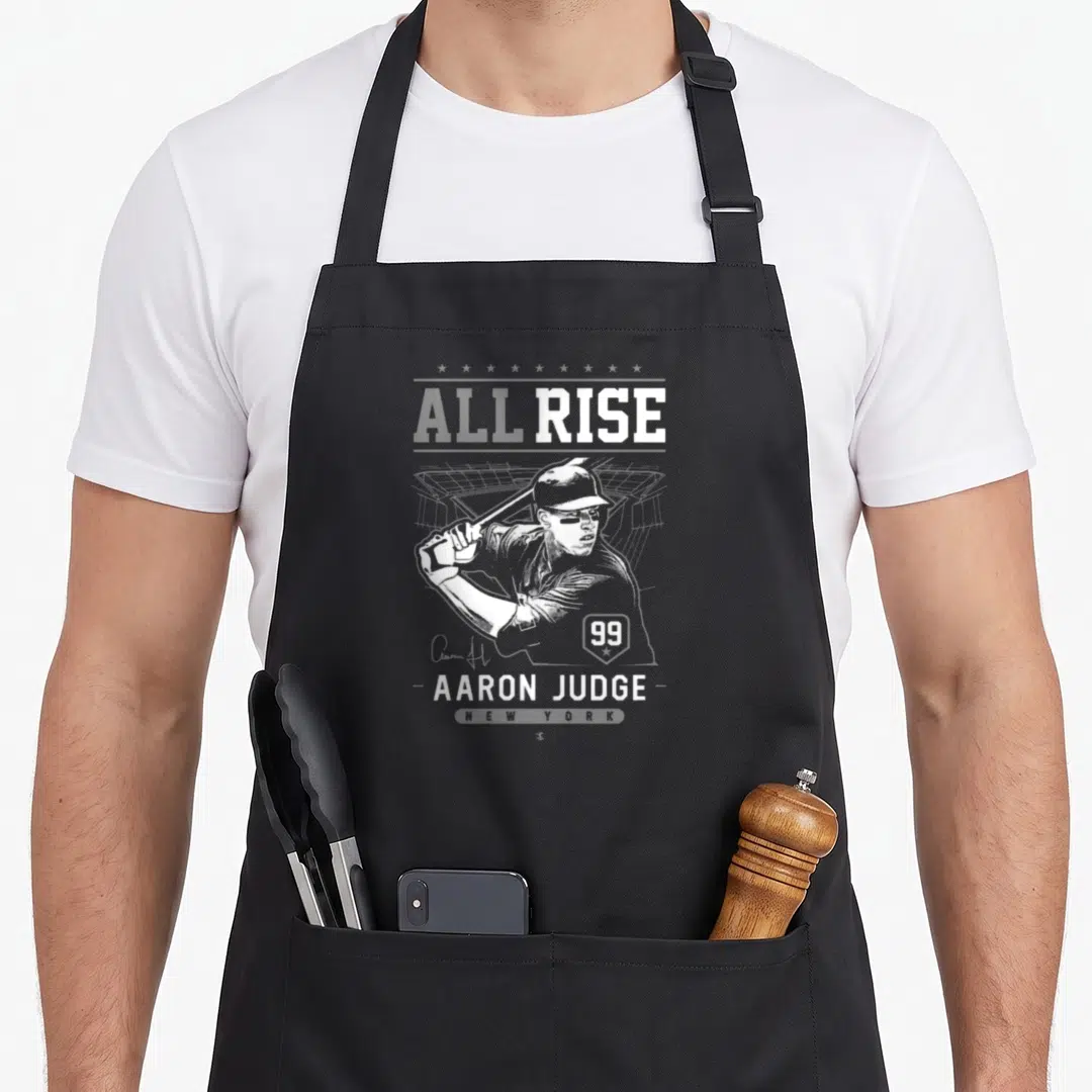 Rise judge apron - White distressed graphic of Aaron Judge swinging a bat with text ALL RISE and number 99 — shown on a black cotton canvas apron against a white background
