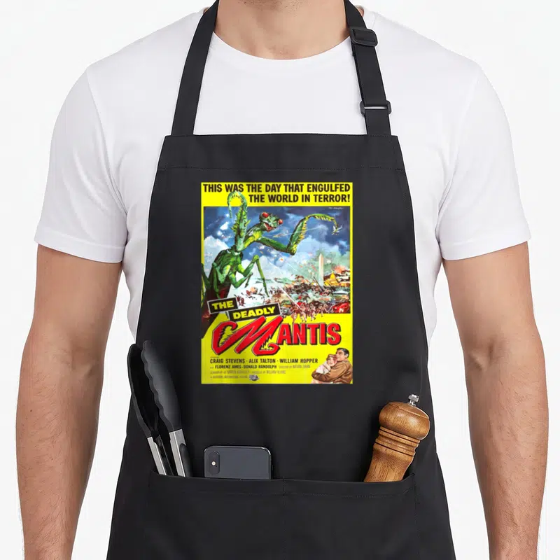 Mantis science apron - Vintage movie poster print of giant green mantis attacking city with red title text on yellow — shown on a black cotton canvas apron against a white background