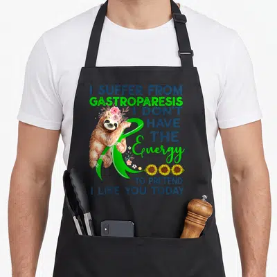 Gastroparesis sloth apron - Cartoon sloth with pink flowers holding green ribbon next to blue text and yellow sunflowers — shown on a black cotton canvas apron against a white background