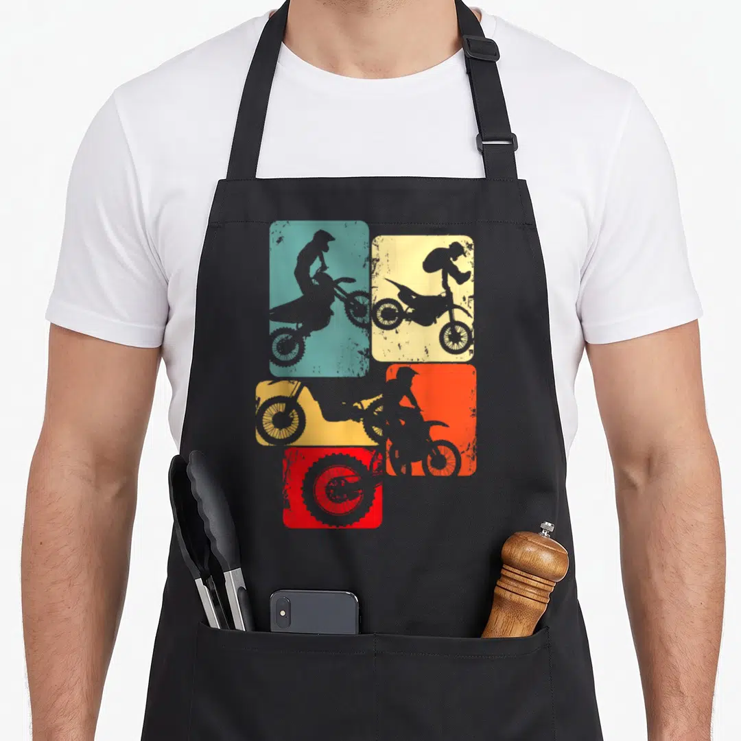 Rider motocross enduro bike apron - Four teal yellow orange and red rounded squares with grey dirt bike rider — shown on a black cotton canvas apron against a white background